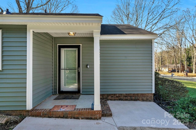 entrance to property featuring a shingled roof