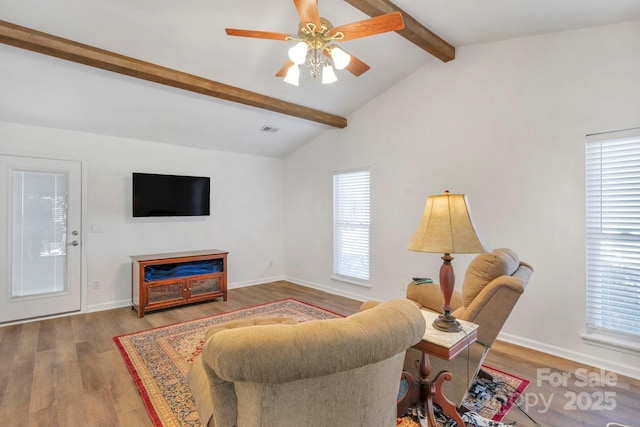 living room with a ceiling fan, lofted ceiling with beams, baseboards, and wood finished floors