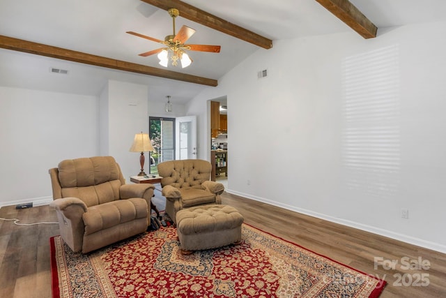 living area featuring vaulted ceiling with beams, wood finished floors, visible vents, and baseboards