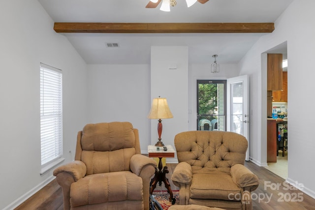 sitting room featuring lofted ceiling with beams, wood finished floors, visible vents, and baseboards