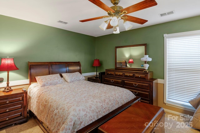 bedroom with baseboards, visible vents, a ceiling fan, and light colored carpet