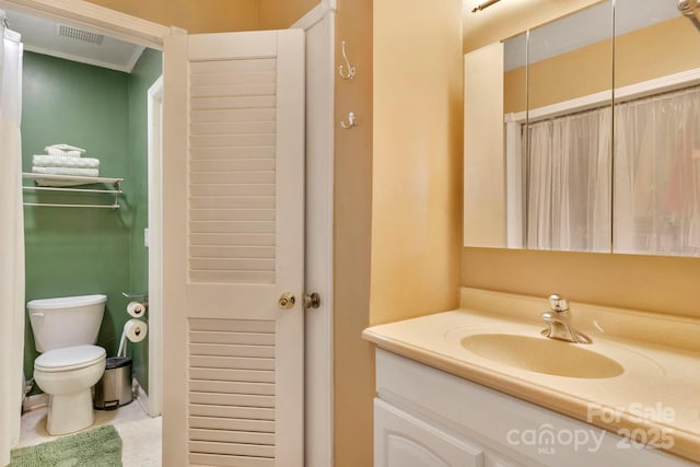 bathroom with toilet, ornamental molding, vanity, and visible vents