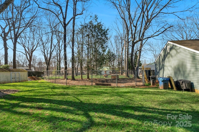 view of yard with an outbuilding, fence, and a storage shed