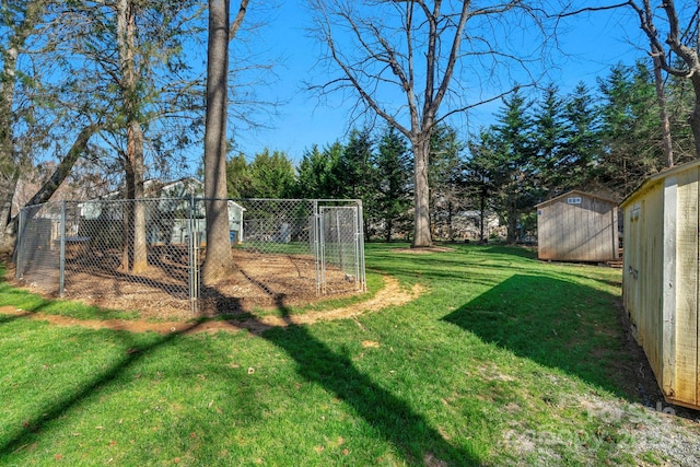 view of yard featuring a storage shed, fence, and an outbuilding