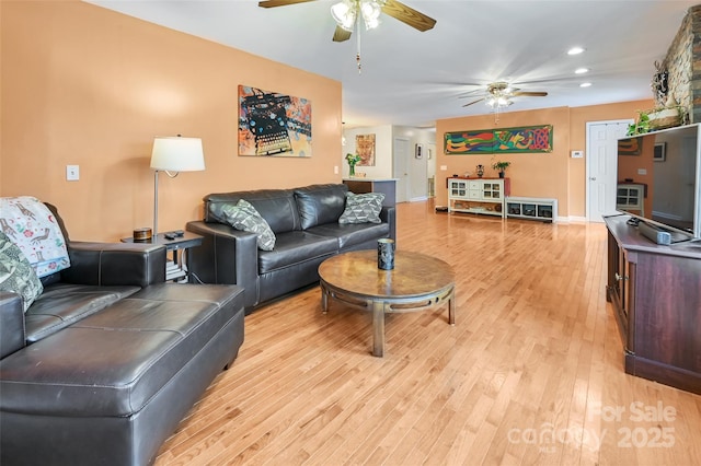 living area with a ceiling fan, recessed lighting, light wood-style flooring, and baseboards