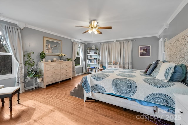 bedroom with ornamental molding, a ceiling fan, and wood finished floors