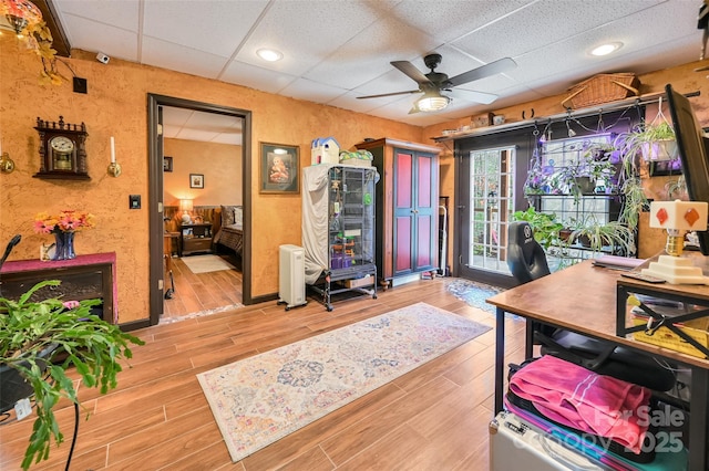 home office with light wood-style flooring, a ceiling fan, a drop ceiling, and recessed lighting