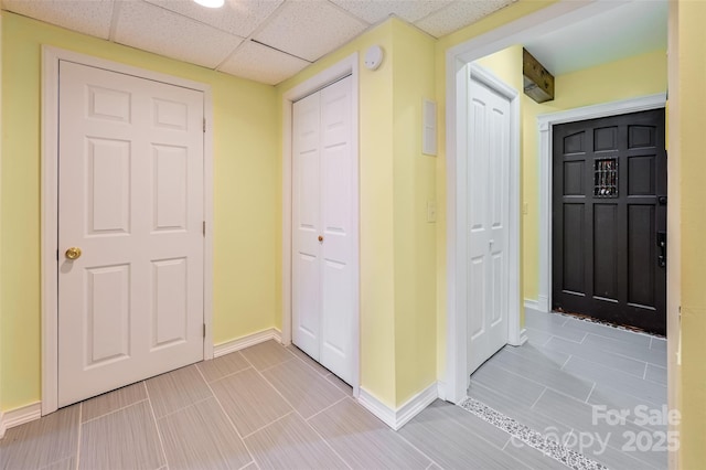 hallway with baseboards and a drop ceiling