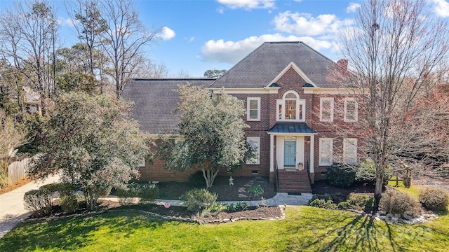 view of front facade with a front yard, crawl space, brick siding, and fence