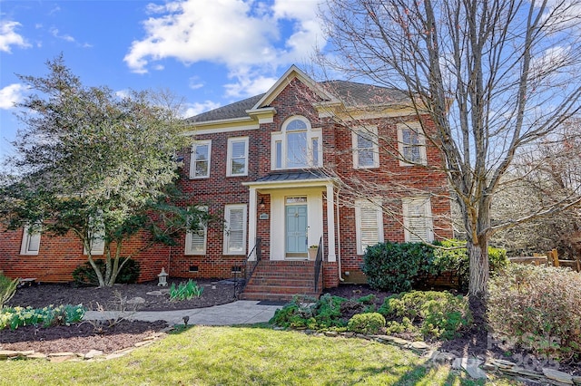 colonial home featuring brick siding