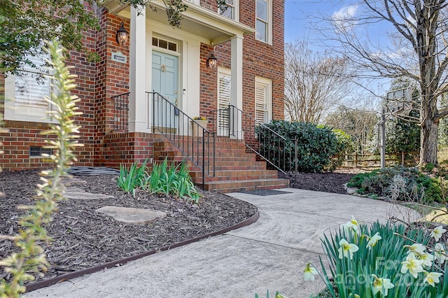 entrance to property featuring brick siding