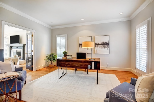 home office with crown molding, baseboards, and light wood-style floors