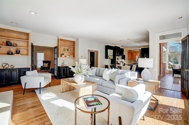 living area with ornamental molding, recessed lighting, and light wood-style floors