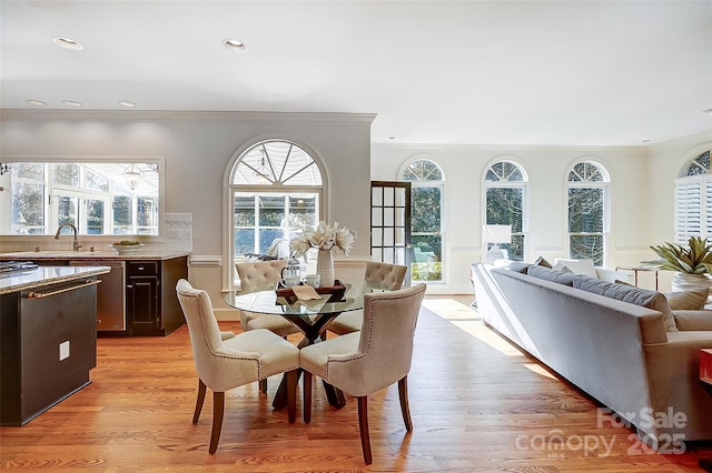 dining area featuring ornamental molding, plenty of natural light, and light wood-style floors