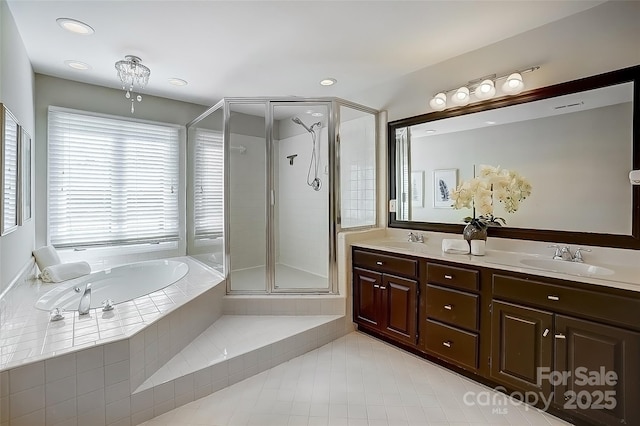 bathroom with double vanity, a garden tub, a shower stall, and a sink