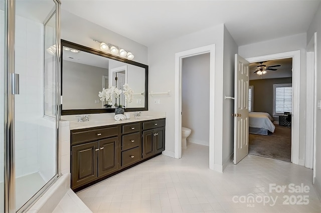 ensuite bathroom with double vanity, a sink, toilet, and ensuite bathroom