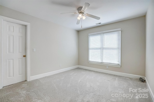 spare room featuring a ceiling fan, baseboards, visible vents, and carpet flooring