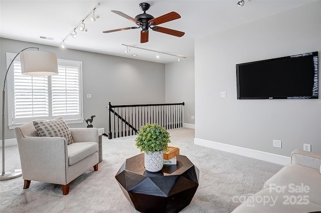 carpeted living area with a ceiling fan, visible vents, and baseboards