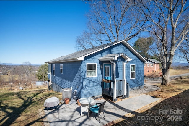 exterior space featuring a yard, a patio area, and cooling unit