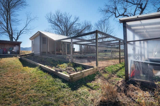 view of outbuilding featuring an outdoor structure and a garden