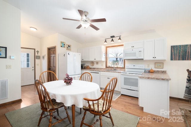 dining room featuring baseboards, visible vents, ceiling fan, and light wood finished floors