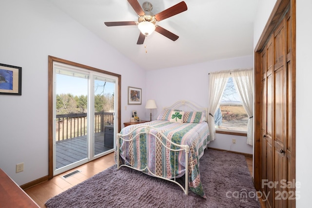 bedroom with lofted ceiling, access to outside, visible vents, and baseboards