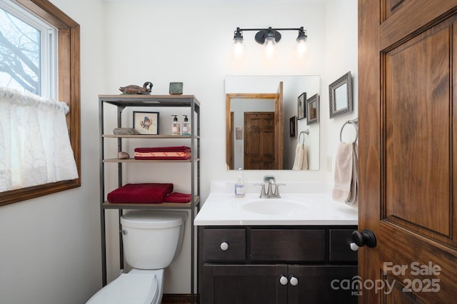 half bath featuring toilet and vanity