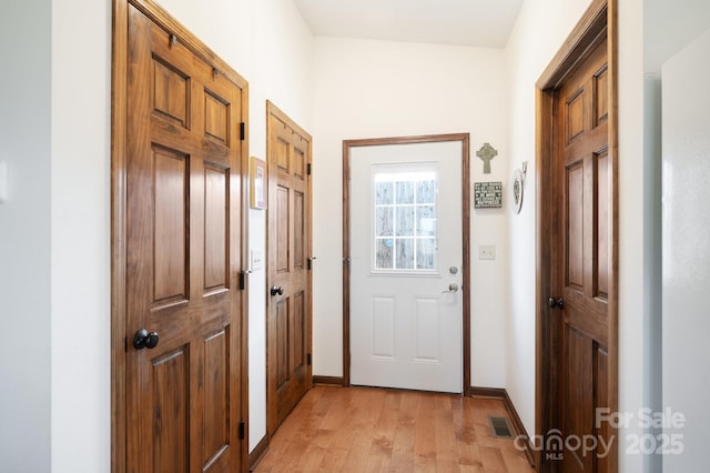 entryway with light wood-type flooring, visible vents, and baseboards