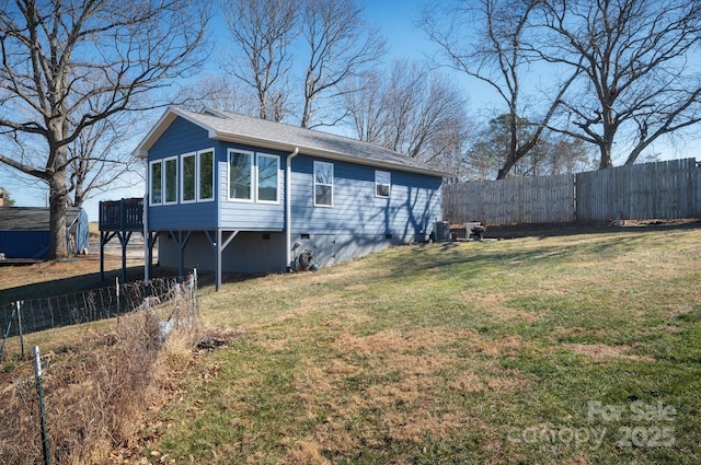 view of property exterior with a lawn, cooling unit, and fence