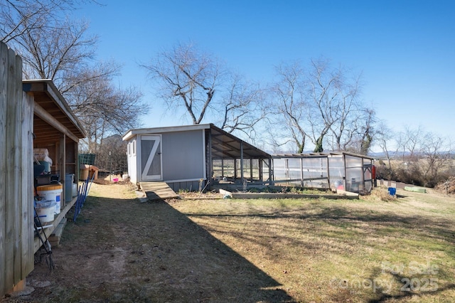 view of yard with a greenhouse and an outdoor structure