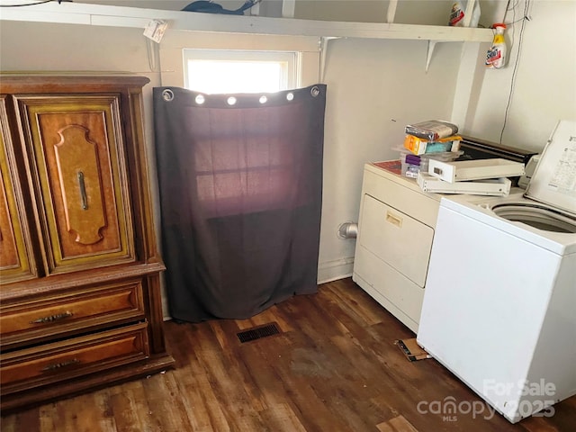 laundry area with dark wood-type flooring, laundry area, visible vents, and washer and clothes dryer