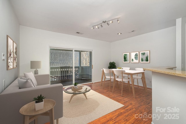 living room featuring visible vents and wood finished floors