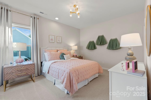 bedroom with light colored carpet and an inviting chandelier