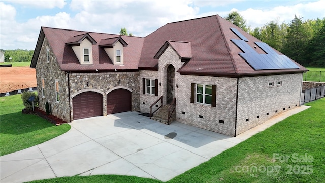 view of front of property featuring an attached garage, concrete driveway, stone siding, crawl space, and a front yard