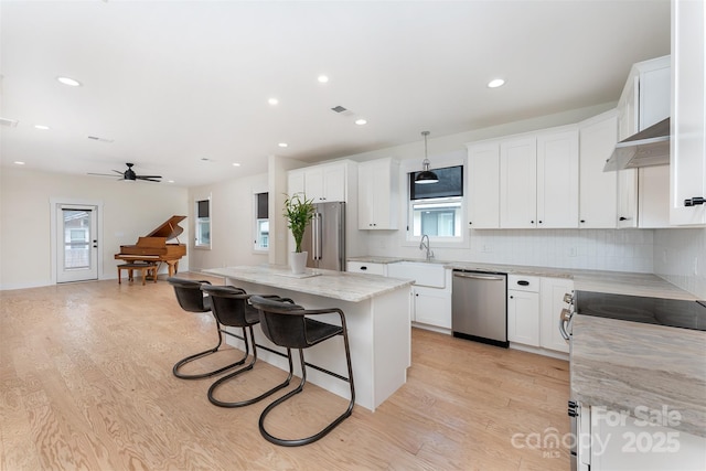 200 Stafford St, Black Mountain, NC 28711 - kitchen featuring a breakfast bar area, a center island, stainless steel appliances, under cabinet range hood, and a sink