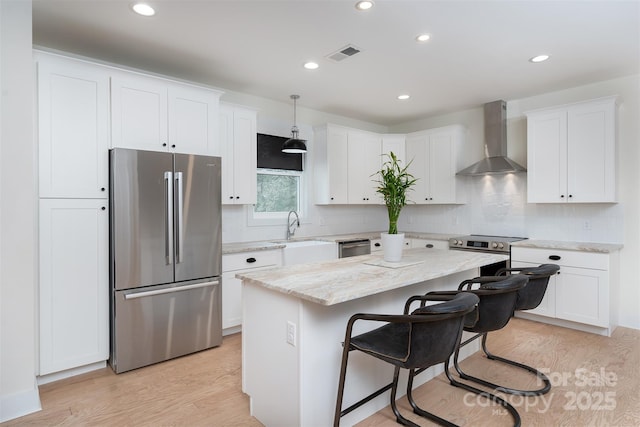 200 Stafford St, Black Mountain, NC 28711 - kitchen with wall chimney range hood, light wood-style flooring, visible vents, and freestanding refrigerator