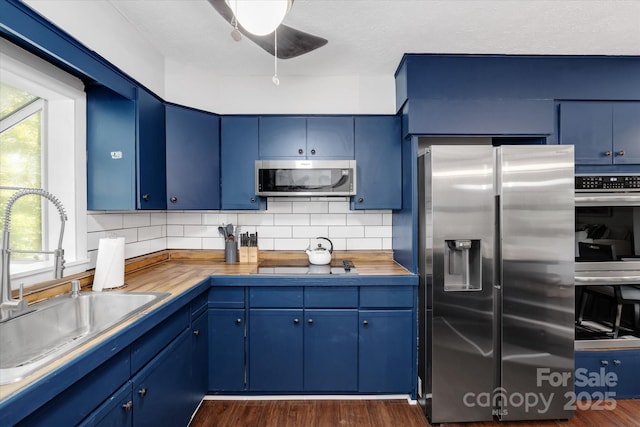 kitchen featuring blue cabinetry, stainless steel appliances, and a sink