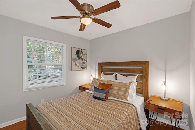 bedroom featuring ceiling fan, baseboards, and wood finished floors