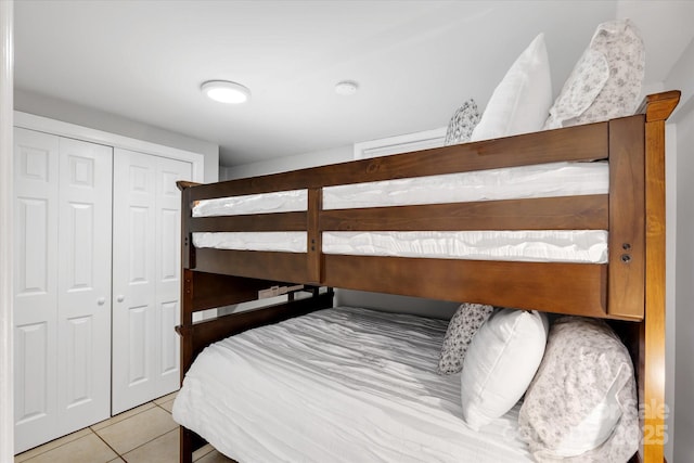 bedroom with a closet and light tile patterned flooring