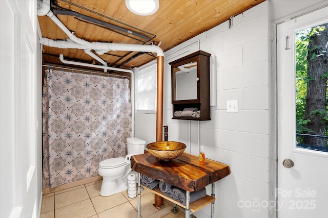 full bathroom featuring wooden ceiling, tile patterned flooring, toilet, a shower with shower curtain, and a sink