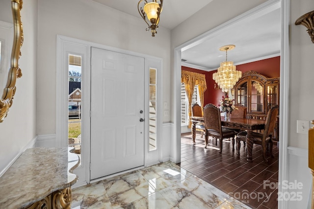 foyer entrance featuring a chandelier, plenty of natural light, wood finished floors, and baseboards