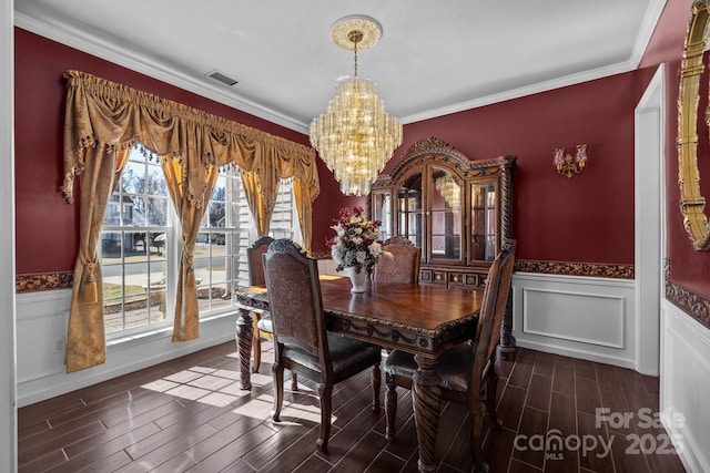 dining space featuring visible vents, a wainscoted wall, wood tiled floor, crown molding, and a chandelier