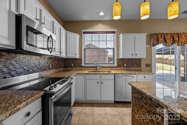 kitchen with a healthy amount of sunlight, appliances with stainless steel finishes, white cabinets, and a sink