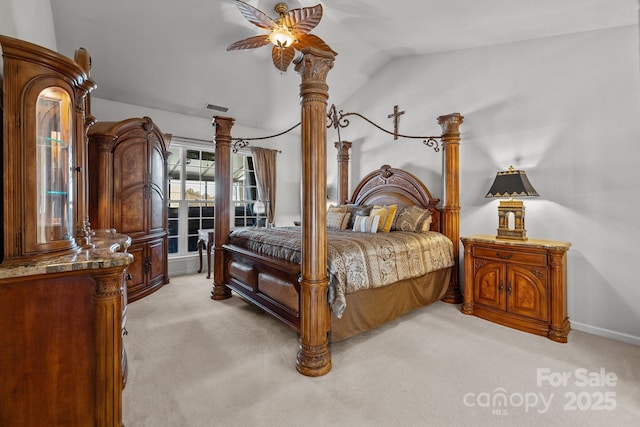 bedroom featuring light carpet, lofted ceiling, and visible vents