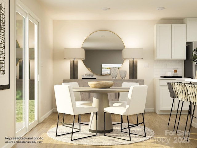 dining room featuring light wood-type flooring and baseboards