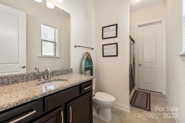 full bath with toilet, a shower stall, baseboards, and vanity