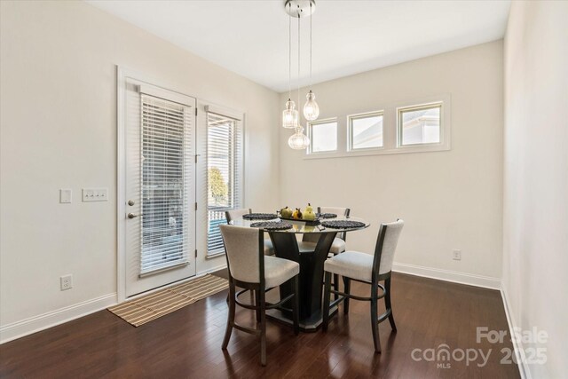 dining space with dark wood-style flooring and baseboards