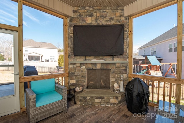 sunroom / solarium with an outdoor stone fireplace