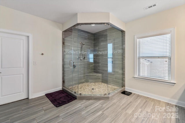 bathroom with visible vents, a shower stall, and baseboards