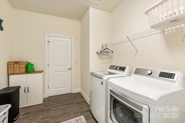 washroom featuring laundry area, wood finish floors, washing machine and dryer, and baseboards